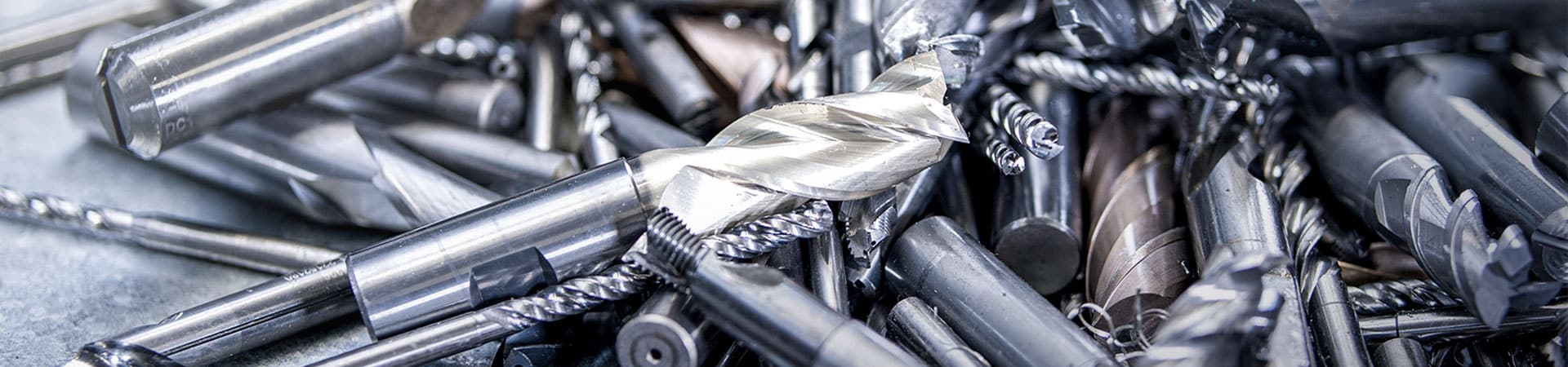 Ein gro?er Haufen von gebrauchten Metallwerkzeugen und Schneidwerkzeugen auf einem Tisch, die für das Recycling und die Wiederverwendung in der Kreislaufwirtschaft bereit sind